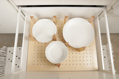 A white shelf with three white bowls placed on it, arranged in a grid-like pattern.